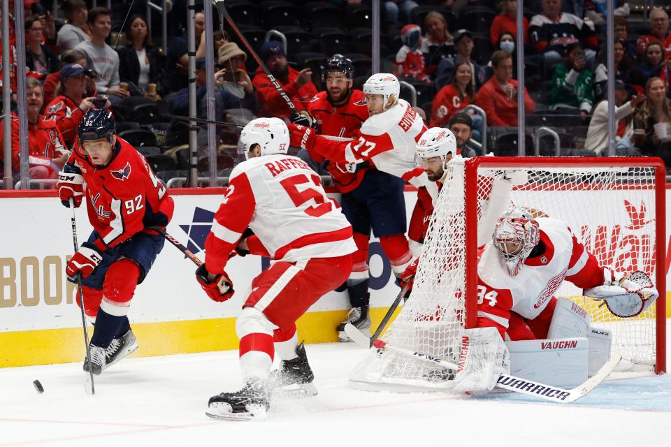 Capitals center Evgeny Kuznetsov skates with the puck behind Red Wings goaltender Alex Lyon as right wing Brogan Rafferty defends in the first period of the exhibition on Thursday, Sept. 28, 2023, in Washington.