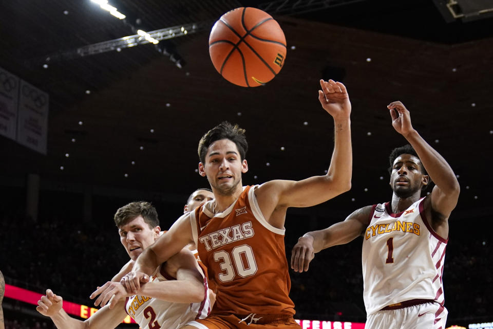 Texas forward Brock Cunningham (30) fights for a loose ball with Iowa State guard Caleb Grill, left, and guard Izaiah Brockington (1) during the second half of an NCAA college basketball game, Saturday, Jan. 15, 2022, in Ames, Iowa. (AP Photo/Charlie Neibergall)