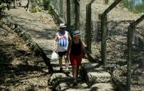 En esta foto del 13 de mayo de 2019 turistas visitan una granja de cocodrilos en la península de Zapata en la provincia de Matanzas, Cuba. (AP Foto / Ismael Francisco)