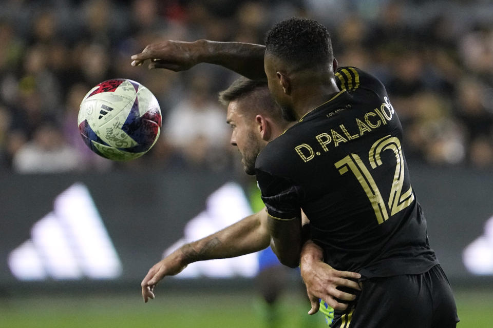 Los Angeles FC defender Diego Palacios, right, battles with Seattle Sounders midfielder Kelyn Rowe during the second half of a Major League Soccer match Wednesday, June 21, 2023, in Los Angeles. (AP Photo/Mark J. Terrill)