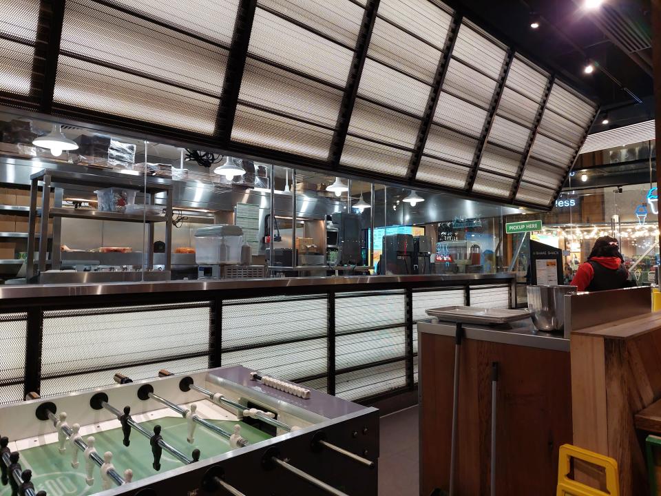 A table football table and kitchen in a Shake Shack restaurant in London