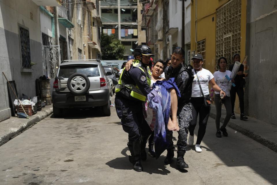 La policía lleva a una mujer al hospital después de dar a luz a su bebé en su apartamento en Caracas, Venezuela, el miércoles 8 de marzo de 2023. Las enfermeras que estaban manifestándose en zonas cercanas para exigir mejoras salariales en el Día Internacional de la Mujer la ayudaron en las tareas de parto del bebé y cortaron el cordón umbilical. (AP Foto/Ariana Cubillos)