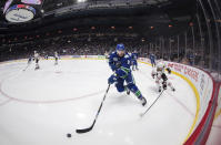 Vancouver Canucks' J.T. Miller (9) skates with the puck in front of Chicago Blackhawks' Duncan Keith (2) during the second period of an NHL hockey game Wednesday, Feb. 12, 2020, in Vancouver, British Columbia. (Darryl Dyck/The Canadian Press via AP)