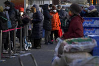 Residents wearing face masks stand in line to enter a supermarket stack with goods in Beijing, Thursday, Dec. 1, 2022. More cities eased anti-virus restrictions as Chinese police tried to head off protests Thursday while the ruling Communist Party prepared for the high-profile funeral of the late leader Jiang Zemin. (AP Photo/Andy Wong)