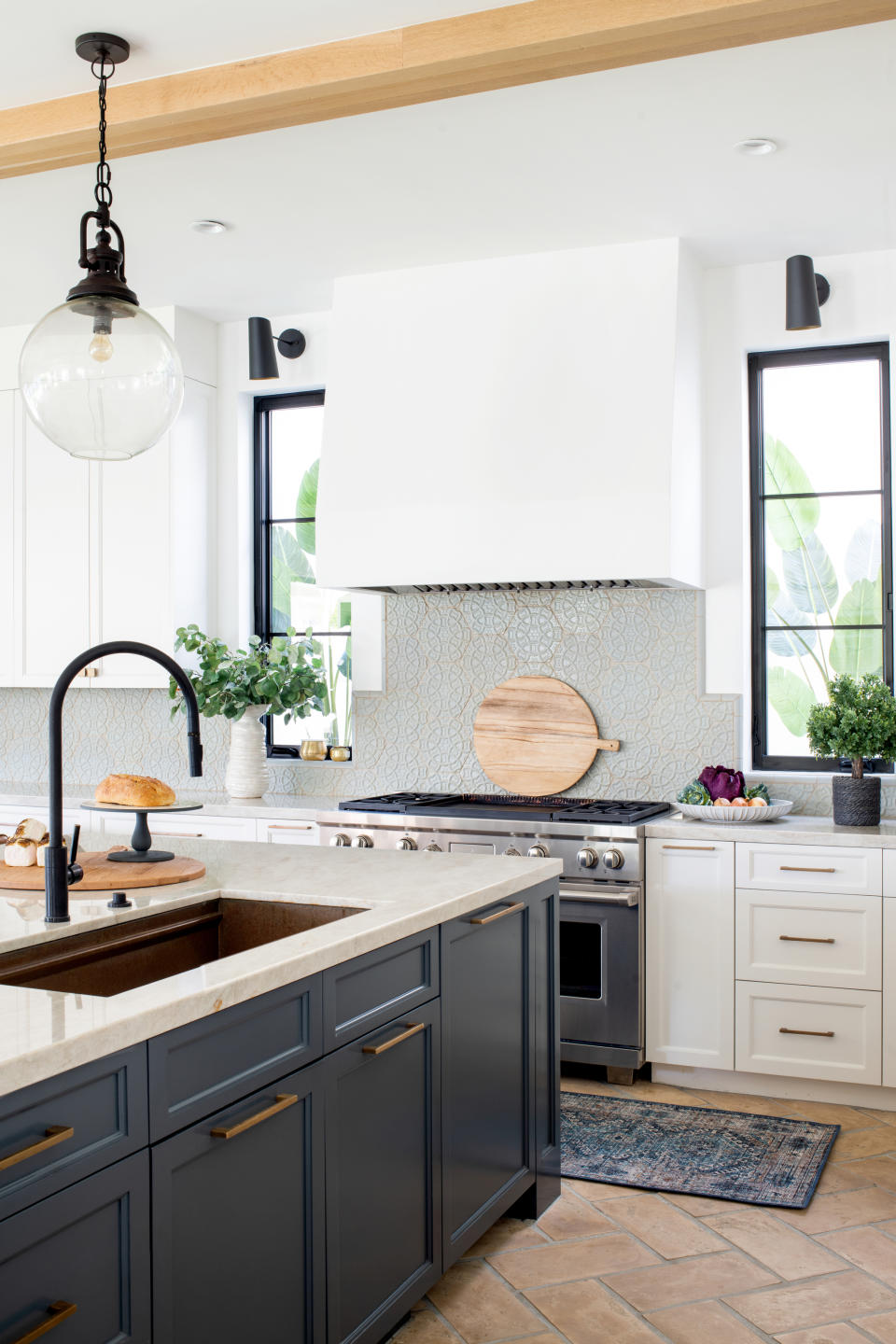 Cream kitchen with navy island, brown worktop and copper sink