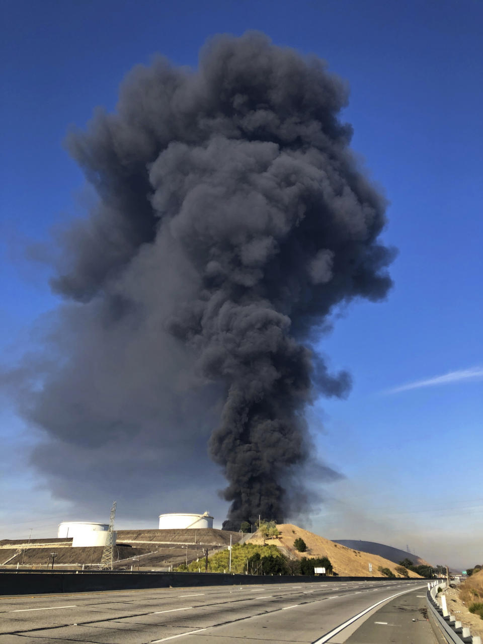 Interstate 80 is closed as a fire at an oil storage facility burns Tuesday, Oct. 15, 2019, in Rodeo, Calif. A fire burning at NuStar Energy LP facility in Crockett, Calif., in the San Francisco Bay Area prompted a hazardous materials emergency that led authorities to order the residents of two communities, including Rodeo, to stay inside with all windows and doors closed. Contra Costa Fire Department spokesman Steve Hill said that an hour into battling the blaze, firefighters seemed to be making progress and were continuing to keep adjacent tanks cooled with water. (AP Photo/Ben Margot)