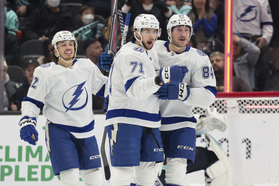 Tampa Bay Lightning center Anthony Cirelli (71) celebrates his goal against the Seattle Kraken with center Alex Barre-Boulet (12) and left wing Tanner Jeannot (84) during the first period of an NHL hockey game Saturday, Dec. 9, 2023, in Seattle. (AP Photo/Jason Redmond)