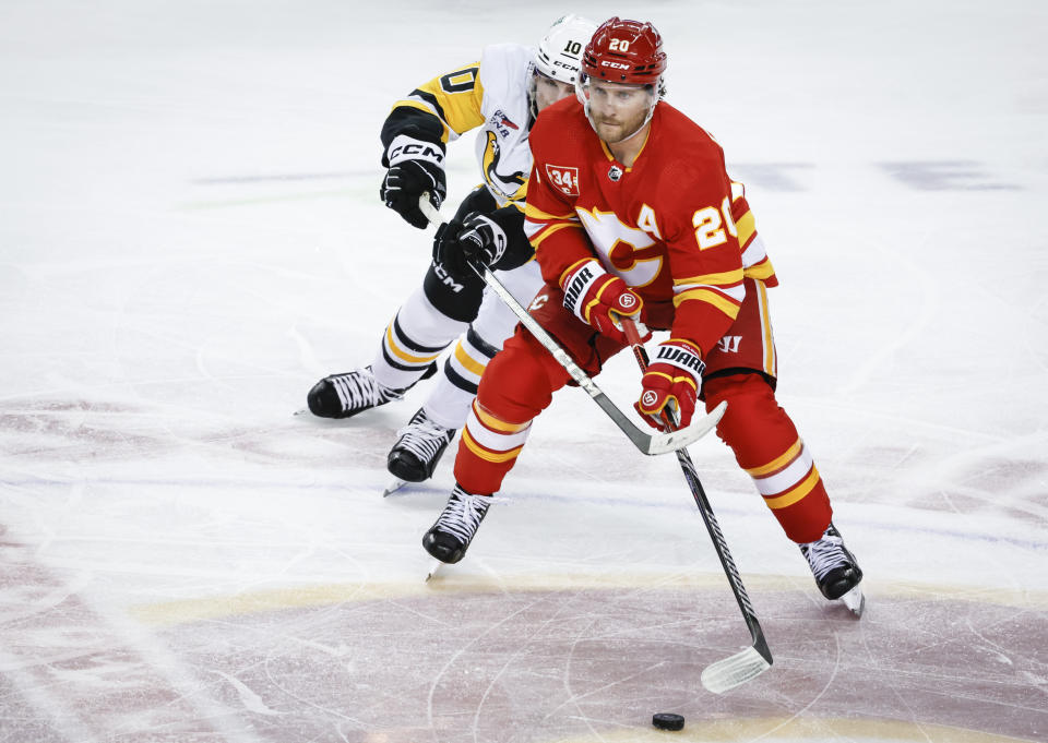 Pittsburgh Penguins forward Drew O'Connor (10) checks Calgary Flames forward Blake Coleman (20) during the third period of an NHL hockey game Saturday, March 2, 2024, in Calgary, Alberta. (Jeff McIntosh/The Canadian Press via AP)