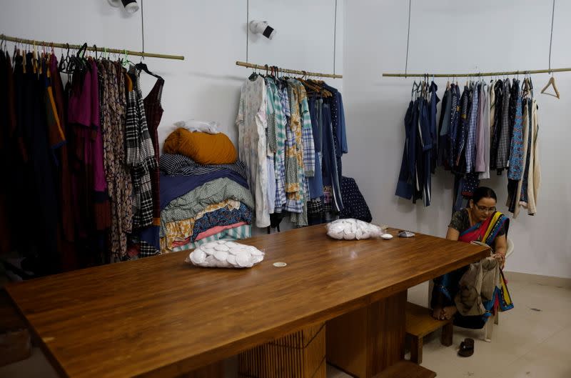 A worker checks the quality of cloth made from discarded fabric waste at a factory in New Delhi