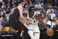 Milwaukee Bucks' Jrue Holiday, right, drives on Toronto Raptors' Yuta Watanabe during the first half of an NBA basketball game Thursday, Dec. 2, 2021, in Toronto. (Chris Young/The Canadian Press via AP)