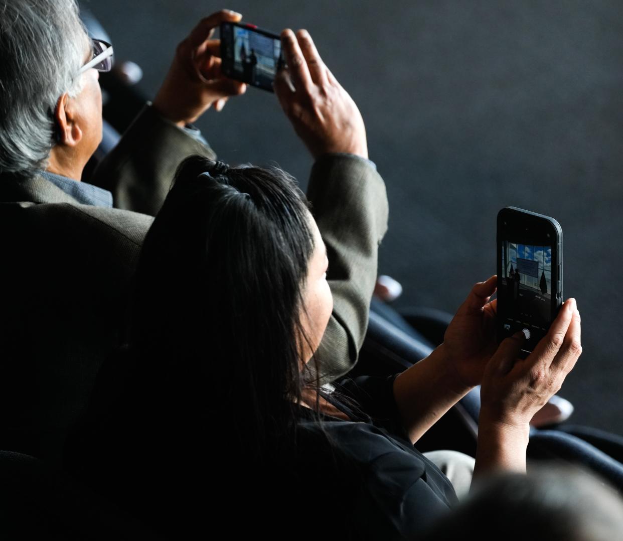 Individuals in the crowd take photos of U.S. Department of Energy Secretary Jennifer M. Granholm as she delivers her speech Wednesday, March 27, 2024 inside of Discovery WorldÕs theater in Milwaukee. She delivers a speech on the AdministrationÕs whole-of-government approach to industrial policy ensuring American businesses and American workers remain at the forefront of the global economy. Ebony Cox / Milwaukee Journal Sentinel