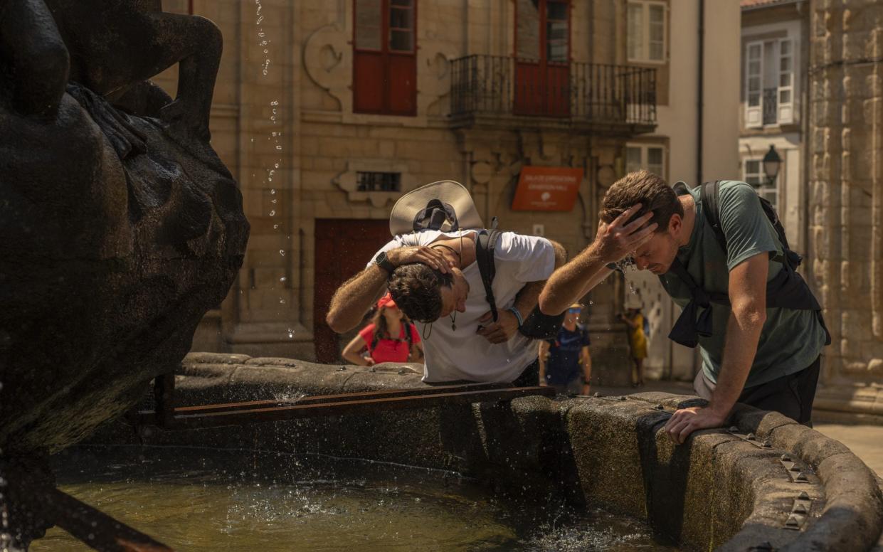 Tourists cool off on a hot summer day in the Spanish city of Santiago de Compostela