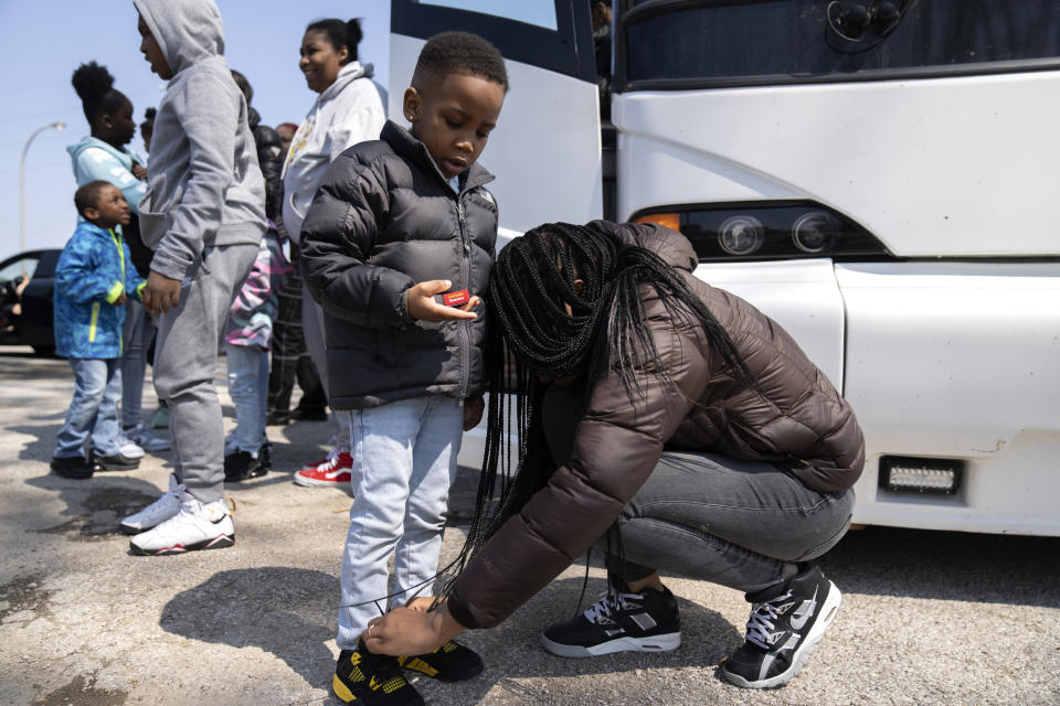 Jada Lesure, 23, ties the shoes of her 4-year-old son Davi Stewart Roberts as they arrive at Logan Correctional Center to visit her mother Erika Ray, his grandmother, Saturday, May 20, 2023, in Lincoln, Illinois. Rare programs like the Reunification Ride, a donation-dependent initiative that buses prisoners' family members from Chicago to Illinois' largest women's prison every month so they can spend time with their mothers and grandmothers, are a crucial lifeline for families, prisoners say. (AP Photo/Erin Hooley)