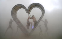 <p>Burning Man participants perform a shibari rope scene during a driving desert dust storm inside the heart of the “Identity Awareness – Family” art project created by artist Shane Pitzer on the 2nd day of the annual Burning Man arts and music festival in the Black Rock Desert of Nevada, Aug. 29, 2017. (Photo: Jim Bourg/Reuters) </p>