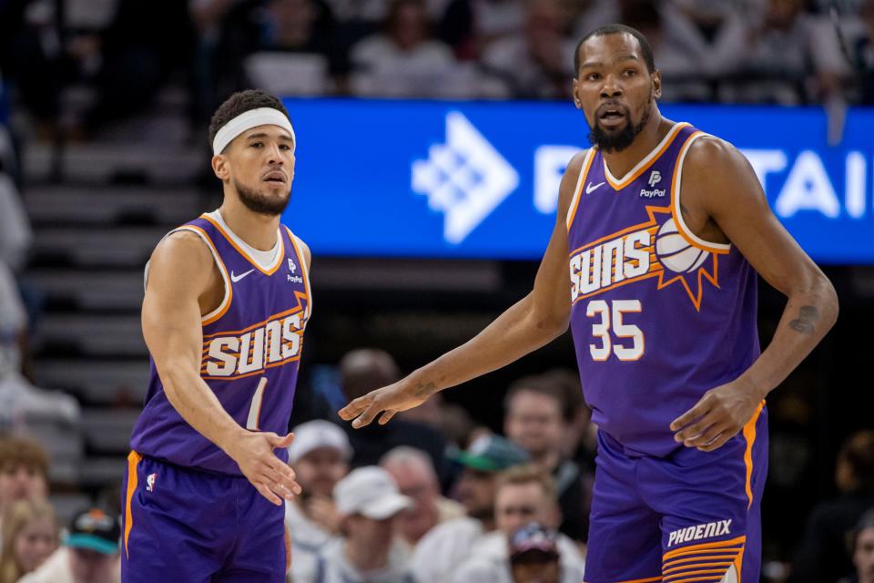 Phoenix Suns guard Devin Booker (1) shakes hands with forward Kevin Durant (35) against the Minnesota Timberwolves in the first half during game one of the first round for the 2024 NBA playoffs at Target Center.