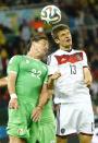 Algeria's Mehdi Mostefa (L) jumps for the ball with Germany's Thomas Mueller during their 2014 World Cup round of 16 game at the Beira Rio stadium in Porto Alegre June 30, 2014.REUTERS/Stefano Rellandini