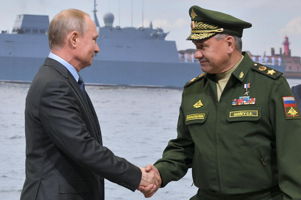 Russian President Vladimir Putin, left, and Russian Defense Minister Sergei Shoigu shake hands during a visit a shipyard in St. Petersburg, Russia, Tuesday, April 23, 2019. Putin said the government will pursue an ambitious navy modernization effort. (Alexei Druzhinin, Sputnik, Kremlin Pool Photo via AP)