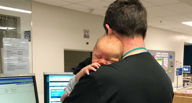 Dr Muir Wallace of Waikato Hospital was pictured cuddling a baby while running the emergency department. Source: Facebook/ Waikato Hospital