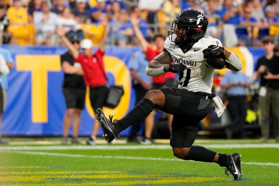 Cincinnati Bearcats running back Corey Kiner (21) breaks through the line for a touchdown in the second quarter of the NCAA football game between the Pittsburgh Panthers and the Cincinnati Bearcats at Acrisure Stadium in Pittsburgh on Saturday, Sept. 9, 2023. The Bearcats led 20-7 at halftime.