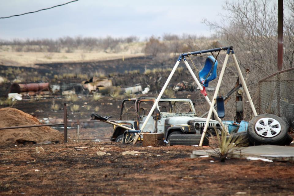 A burned swing set and Jeep sit behind a home Thursday, Feb. 29, 2024, along State Highway 136 between Fritch and Borger in the Texas Panhandle. The Windy Deuce Fire, which burned through the area and caused the damage, was estimated at 144,206 acres Sunday and 55 percent contained.