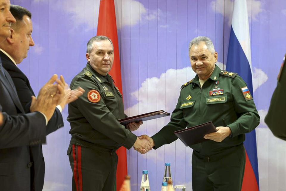 FILE - In this handout photo released by Russian Defense Ministry Press Service on Saturday, Dec. 3, 2022, Russian Defense Minister Sergei Shoigu, right, and Belarusian Defense Minister Viktor Khrenin shake hands during a meeting in Minsk, Belarus. Belarus President Alexander Lukashenko has welcomed thousands of Russian troops to his country, allowed the Kremlin to use it to launch the invasion of Ukraine on Feb. 24, 2022, and offered to station some of Moscow’s tactical nuclear weapons there. But he has avoided having Belarus take part directly in the fighting – for now. (Russian Defense Ministry Press Service via AP, File)