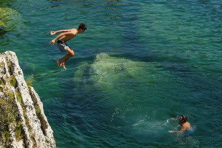 A boy jumps into Cijevna river to cool off near Tuzi as a heatwave hits Montenegro, August 4, 2017. REUTERS/Stevo Vasiljevic