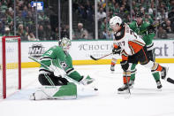 Dallas Stars goaltender Jake Oettinger (29) defends against a shot while under pressure from Anaheim Ducks right wing Frank Vatrano (77) in the second period of an NHL hockey game, Monday, Feb. 6, 2023, in Dallas. (AP Photo/Tony Gutierrez)
