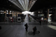 Commuters wait next to empty platforms at Gare du Nord Station, in Paris, Tuesday, Dec. 10, 2019. Only about a fifth of French trains ran normally Tuesday, frustrating tourists finding empty train stations, and most Paris subways were at a halt. French airport workers, teachers and others joined nationwide strikes Tuesday as unions cranked up pressure on the government to scrap changes to the national retirement system. (AP Photo/Francois Mori)