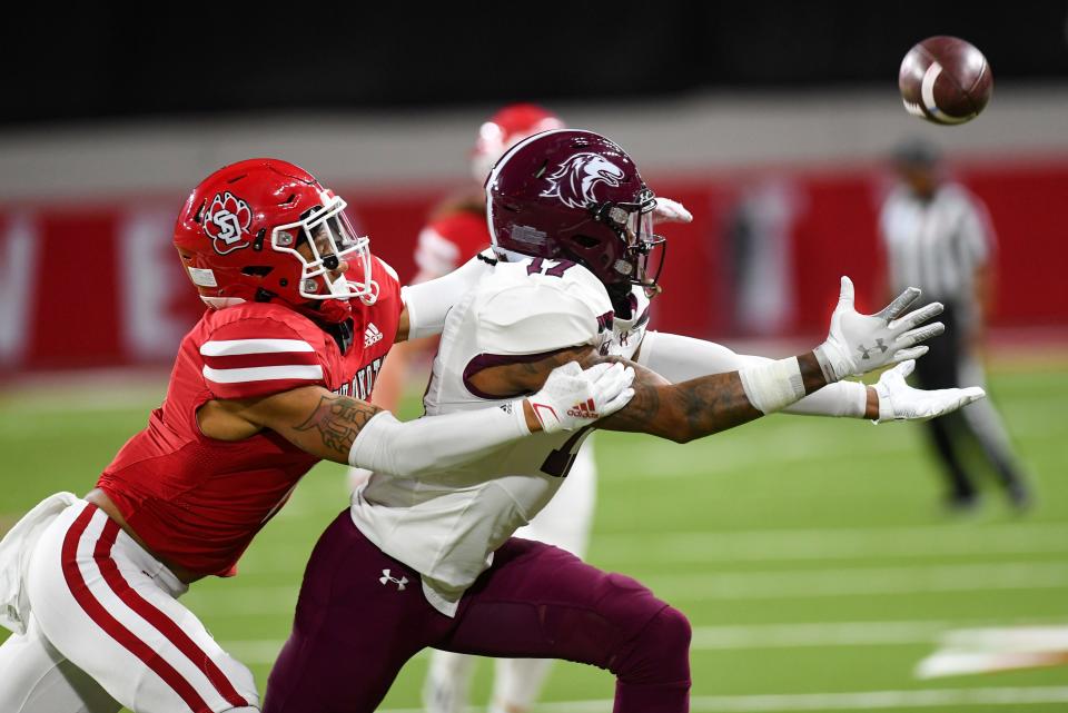 A South Dakota defender tackles Southern Illinois' Landon Lenoir before he can catch a pass during an FCS playoff game on Saturday, November 27, 2021, at the DakotaDome in Vermillion.