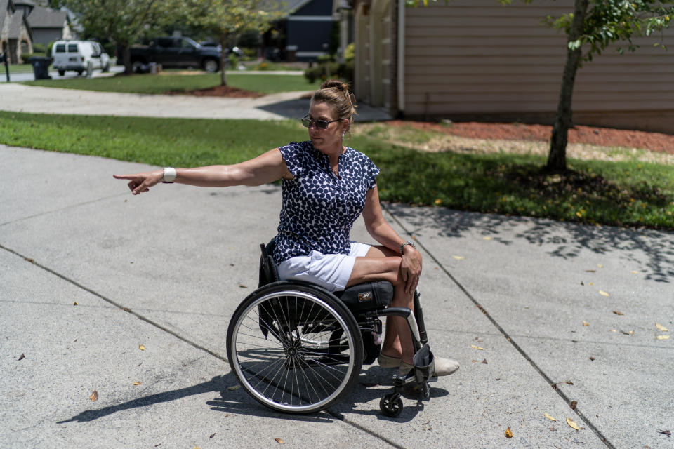 Janet Paulsen points to where she collapsed in her driveway in 2015 while trying to flee as her estranged husband shot her six times at their Acworth, Ga., home, Monday, Aug. 7, 2023. “It took me five years to get up the courage to divorce him, because I knew I would pay a price. And you know what happened when I did? He shot me,” said Paulsen, 53, a former property manager and endurance athlete who was left partially paralyzed in the 2015 shooting. (AP Photo/David Goldman)
