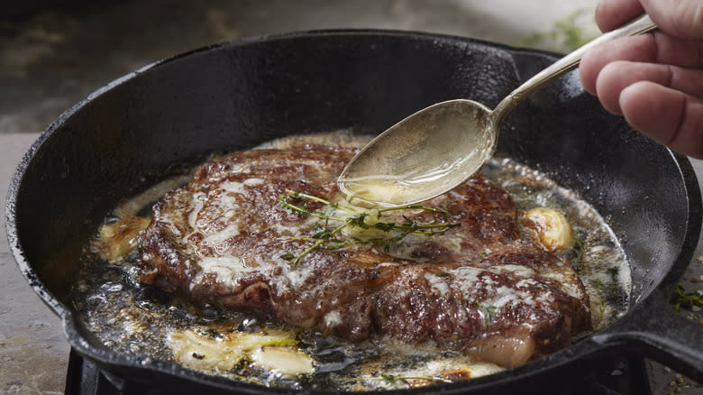 Spoon the fat onto the steak in the skillet.