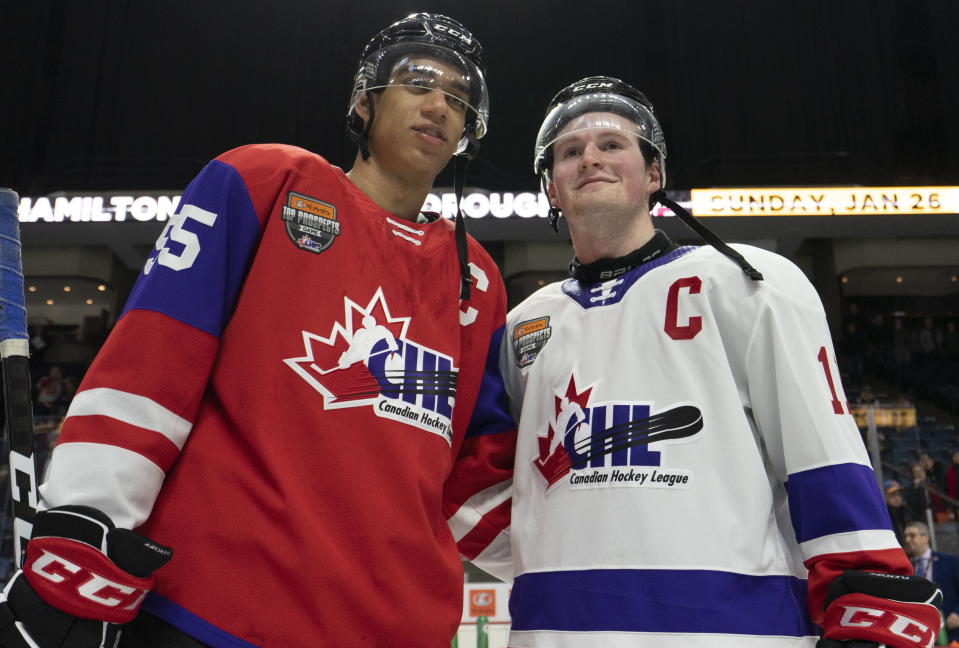 FILE - In this Jan. 16, 2020, file photo, Team Red center Quinton Byfield (55) and Team White left winger Alexis Lafreniere (11) pose for photos following hockey's CHL Top Prospects Game in Hamilton, Ontario. The New York Rangers might be on the clock in owning the No. 1 pick in the NHL draft on Tuesday, Oct. 6. That, and the prospect of selecting Quebec star forward Alexis Lafreniere, doesn't mean the still-retooling Rangers will be anywhere closer to being a contender, team president John Davidson cautions. (Peter Power/The Canadian Press via AP)