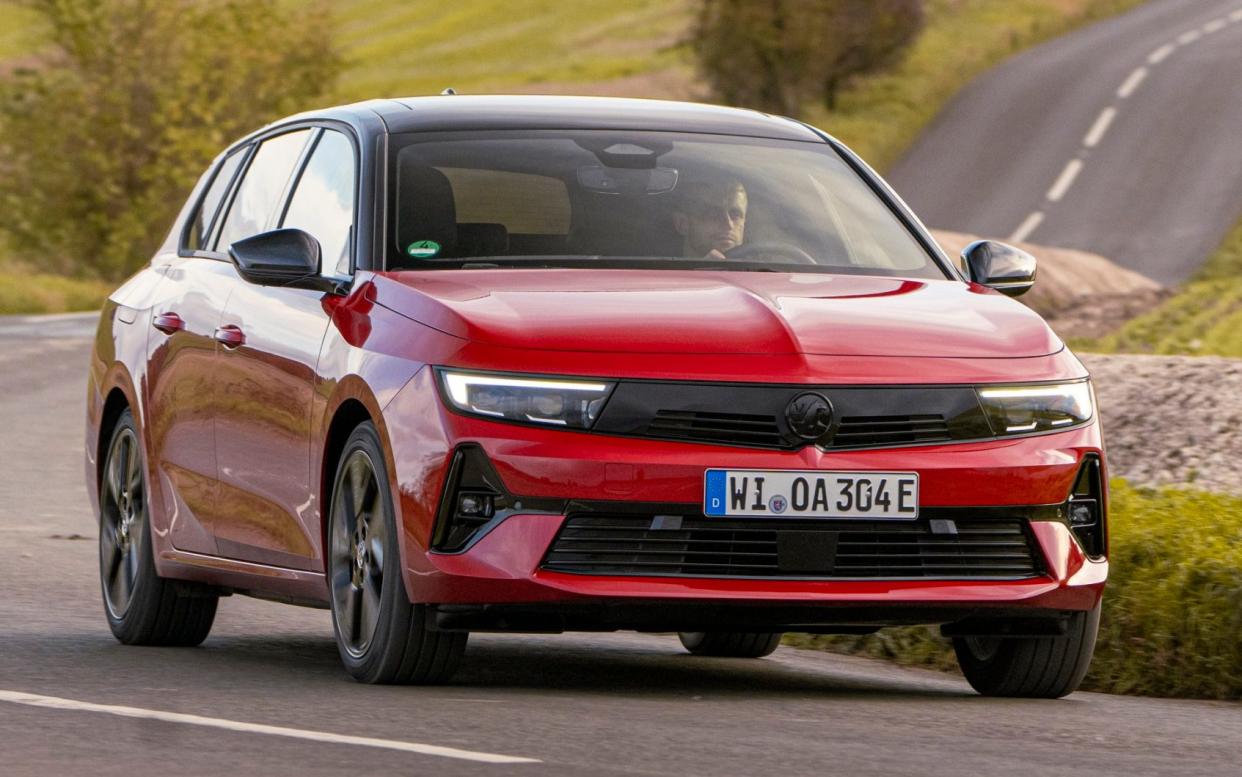 A red Vauxhall Astra Electric Sports Tourer on a bendy country road