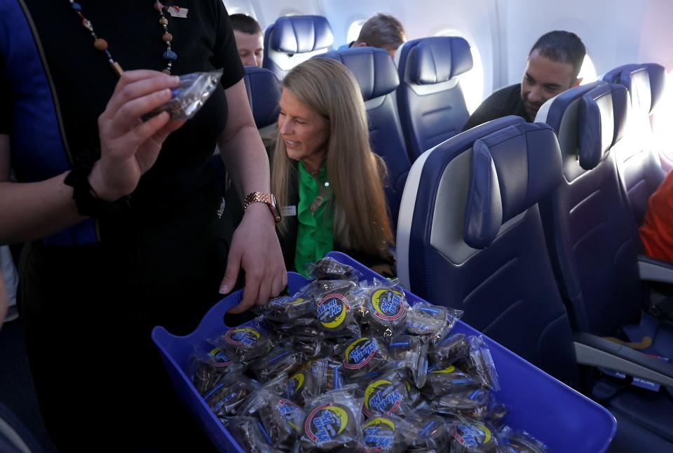 IN FLIGHT - APRIL 8: A Southwest flight attendant hands out Moon Pies during Southwest Flight 1252 from Dallas, Texas to Pittsburgh, Pennsylvania before the plane passed through the zone of totality en route to Pittsburgh, Pennsylvania on April 8, 2024. Millions of people flocked to areas across North America in the "Path of Totality" to experience a total solar eclipse. During the event, the moon will pass between the sun and the earth, seemingly covering the sun. (Photo by Justin Sullivan/Getty Images)