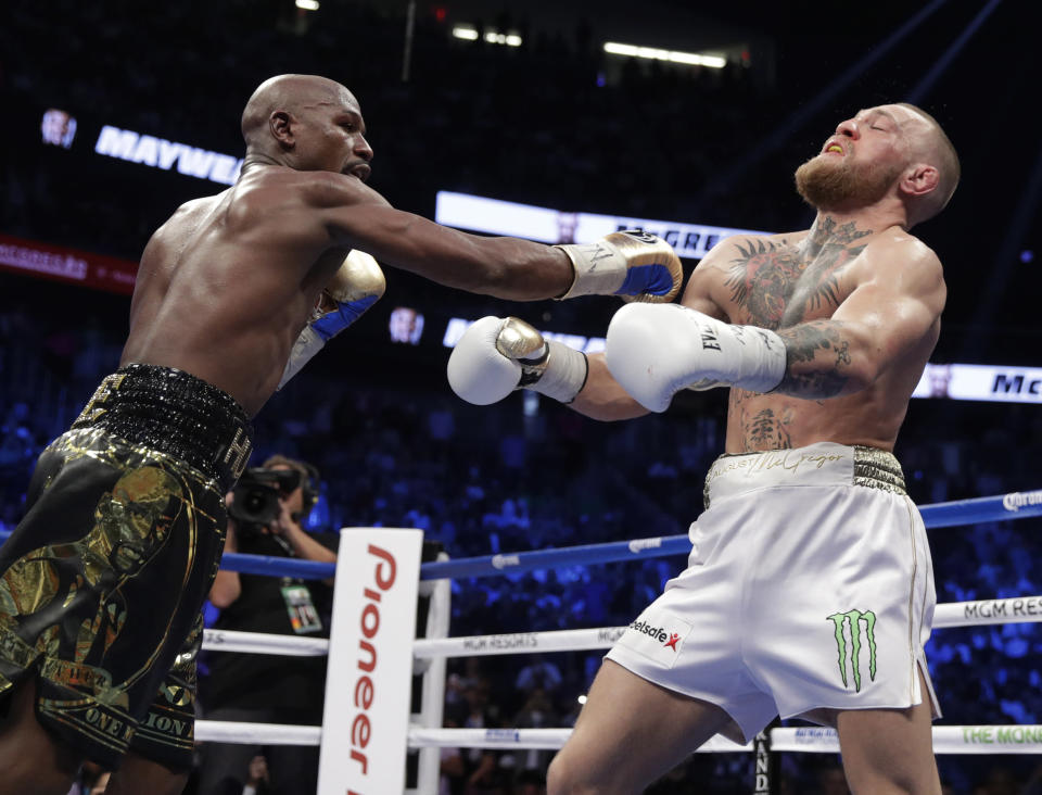 Floyd Mayweather Jr. hits Conor McGregor in a super welterweight boxing match Saturday, Aug. 26, 2017, in Las Vegas. (AP)