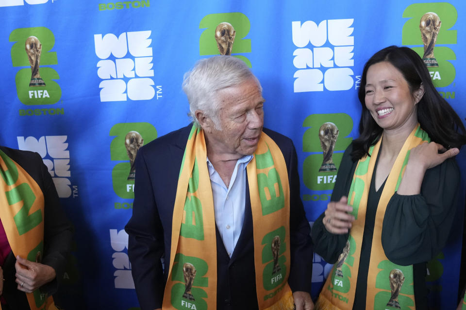 New England Patriots owner Robert Kraft, center, and Boston Mayor Michelle Wu, right, stand for a photograph during ceremonies held to introduce Boston Soccer 2026's local branding for the 2026 World Cup, Thursday, May 18, 2023, in Boston. Gillette Stadium in Foxborough, Mass., is one of 16 venues in the United States, Mexico and Canada tapped to host soccer matches for the international sporting event. (AP Photo/Steven Senne)