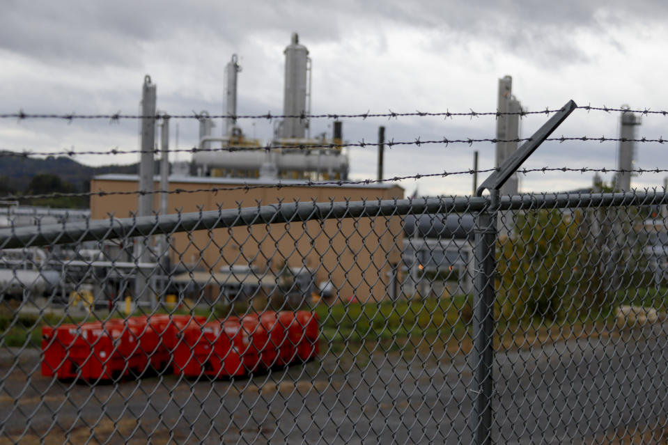 In this Oct. 17, 2019, photo, the MarkWest Bluestone Gas Processing Plant is visible behind the roadside fencing in Evans City, Pa. President Donald Trump has aligned with Pennsylvania's natural gas industry, but his support for the industry in the nation's No. 2 natural gas state may not yield the expected political boost in what is perhaps the nation's premier presidential battleground state. In parts of the state critical to his path to victory, opposition to fracking is growing and calls for getting tough on the industry are popular. (AP Photo/Keith Srakocic)