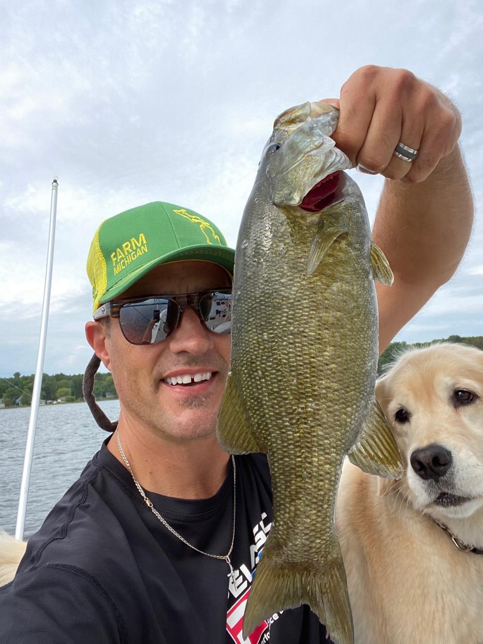 Thad Szott takes a break from selling cars for Szott Auto Group in Holly to fish on Otsego Lake in Gaylord, Michigan, with his dog Nicki on Saturday, Aug. 22, 2020. He sees more and more customers shopping for vehicles to carry dogs.
