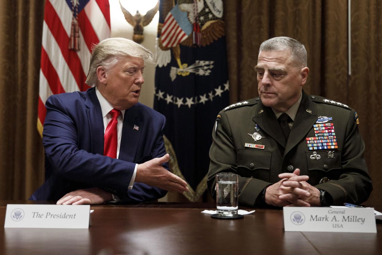 Then-President Donald Trump, extends a hand to Chairman of the Joint Chiefs of Staff Gen. Mark Milley (right)