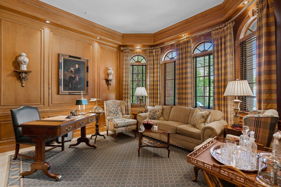 Recessed lighting is tucked into the library’s cornice to highlight the paneling.