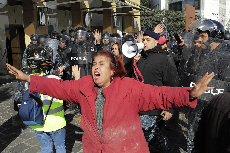 A woman reacts as anti-government protesters clash with police in downtown Beirut, Lebanon, Monday, Jan. 27, 2020. Lebanese security forces scuffled Monday with protesters near the parliament building in downtown Beirut where lawmakers are scheduled to begin a two-day discussion and later approval of the budget amid a crippling financial crisis. (AP Photo/Hassan Ammar)