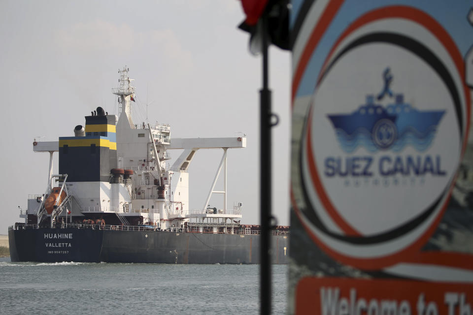 FILE - A cargo ship sails through the town of Ismailia, Egypt, March 30, 2021. Houthi rebels in Yemen are attacking cargo ships plying the waters connecting Asia with Europe and the United States, forcing traffic away from the Suez Canal and around the tip of Africa. (AP Photo/Ayman Aref, File)