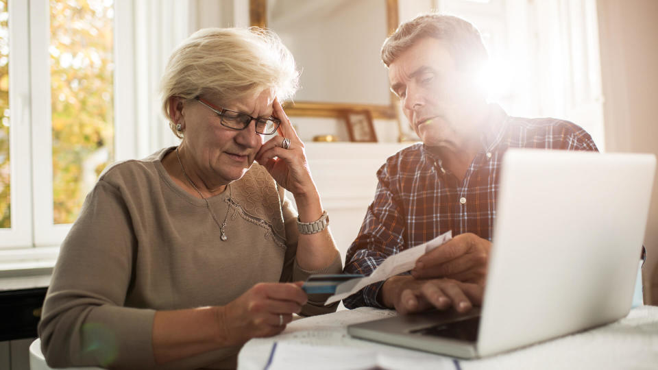 Senior couple sitting at home and having problems with paying their bills.