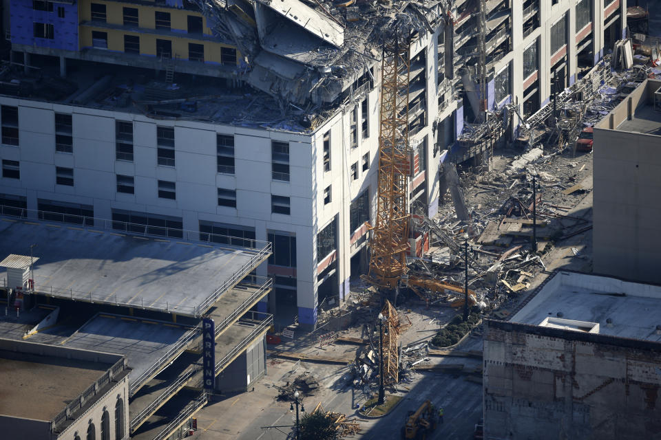 One of two large cranes from the Hard Rock Hotel construction collapse is seen on Rampart Street, in this aerial photo after they cranes were detonated for implosion in New Orleans, Sunday, Oct. 20, 2019. The Saenger Theater, seen in top of frame, appears undamaged from the operation. (AP Photo/Gerald Herbert)