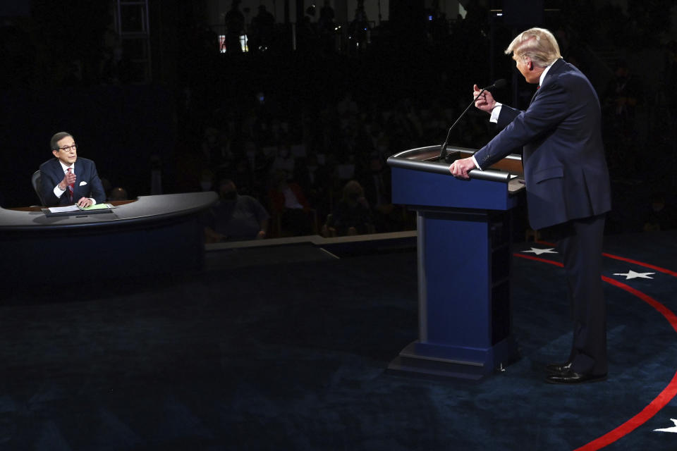 FILE - President Donald Trump gestures to moderator Chris Wallace of Fox News during the first presidential debate in Cleveland on Sept. 29, 2020. Leaders of the Commission on Presidential Debates and moderators of all three debates gathered for a remote debrief Monday night. Two takeaways: increased early voting means the commission is considering earlier debates, and the mute button may be here to stay. (Olivier Douliery/Pool vi AP, File)