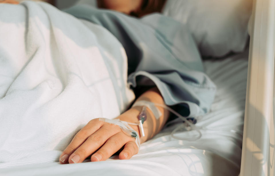 Close-up of a person in bed with tubes attached to their arm