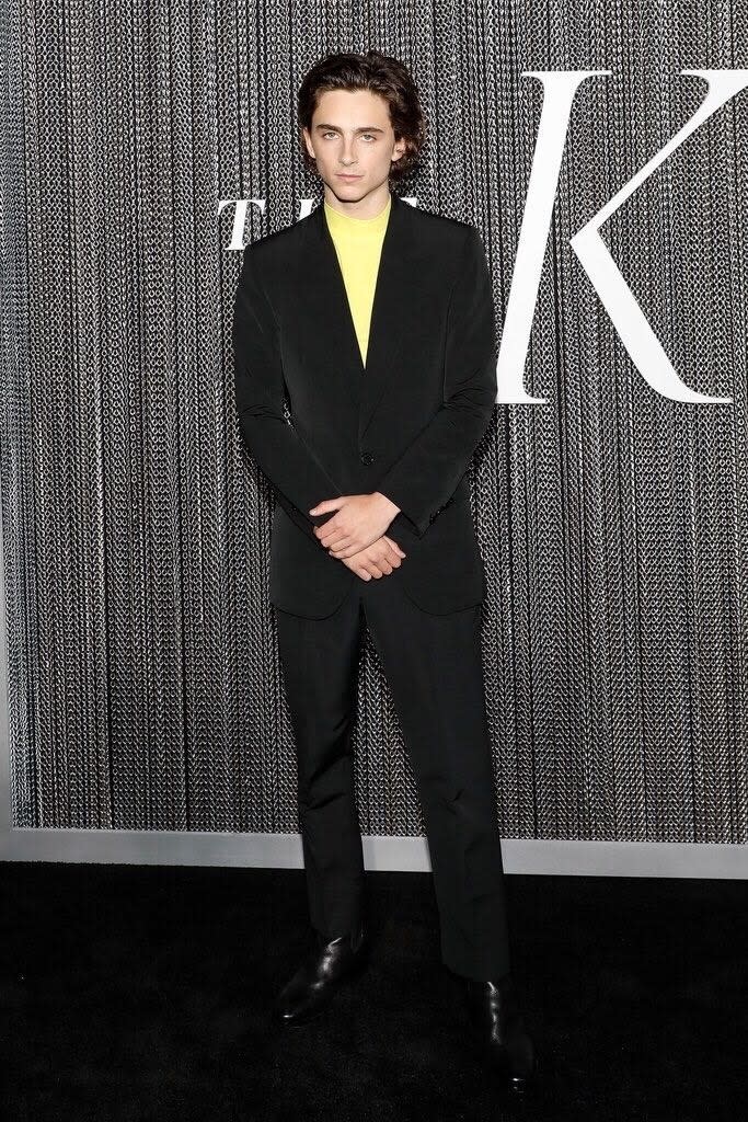 Timothée Chalamet in a look from Spring 2020: an electric yellow mock turtleneck under an almost delicate black suit in a techy fabric.