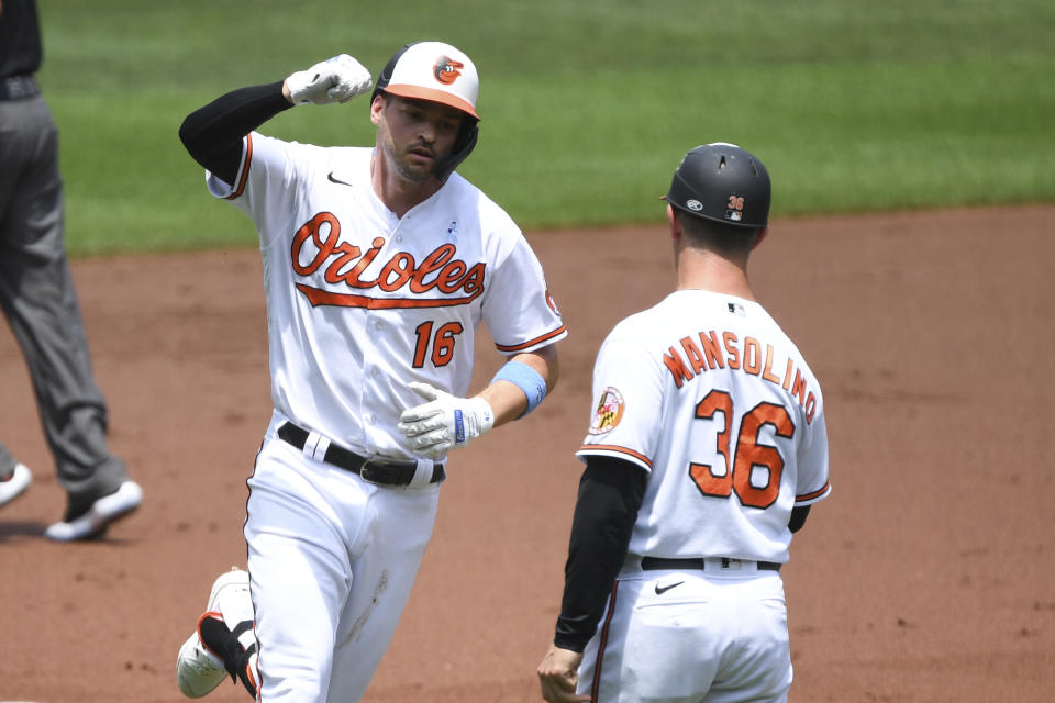 Baltimore Orioles Trey Mancini, left, fist bumps third base coach Tony Mansolino, right, after hitting a first inning home run against Toronto Blue Jays starting pitcher Hyun Jin Ryu during a baseball game, Sunday, June 20, 2021, in Baltimore. (AP Photo/Terrance Williams)