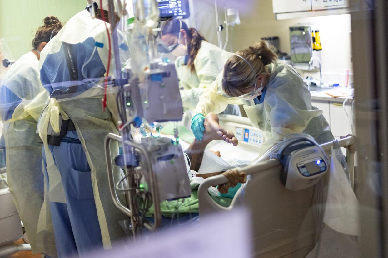 Hospital workers treat a 39-year-old unvaccinated COVID-19 patient in the intensive care unit of St. Luke's Boise Medical Center in Boise, Idaho in August.
