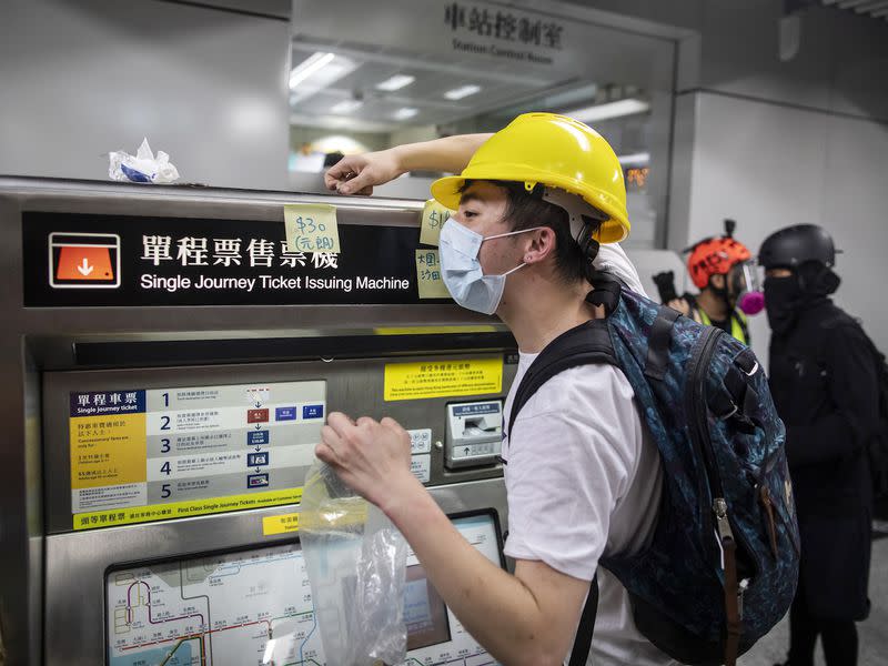 A demonstrator collects Hong Kong dollar coins for fellow protesters to purchase subway tickets, 2019. 